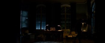 Movie still from “Sinister” (2012), directed by Scott Derrickson – A laptop computer sitting on top of a wooden desk; Wide shot, High angle