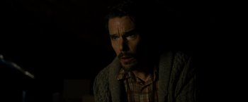 Movie still from “Sinister” (2012), directed by Scott Derrickson – A person wearing a plaid shirt and a sweater; Close Up shot, High angle