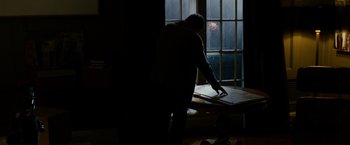 Movie still from “Sinister” (2012), directed by Scott Derrickson – A man standing in front of an open window in a dark room; Medium shot, Over the shoulder angle