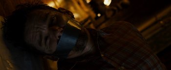 Movie still from “Sinister” (2012), directed by Scott Derrickson – A man with duct tape around his mouth; Close Up shot, High angle