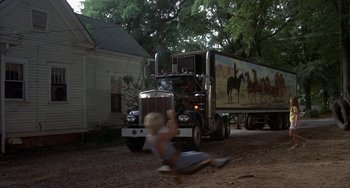 Movie still from “Smokey and the Bandit” (1977), directed by Hal Needham – A large semi truck parked in front of a house; Wide shot, Low angle