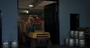 Movie still from “Smokey and the Bandit” (1977), directed by Hal Needham – A man sitting on top of a yellow forklift; Wide shot, High angle