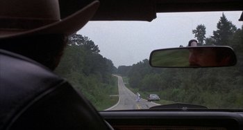 Movie still from “Smokey and the Bandit” (1977), directed by Hal Needham – A view from a car window of a road with cars driving on it; Wide shot, Over the shoulder angle