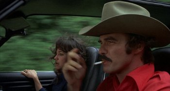 Movie still from “Smokey and the Bandit” (1977), directed by Hal Needham – A man and a woman sitting in the back seat of a car; Close Up shot, Low angle