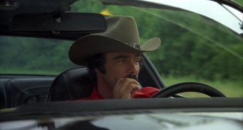Movie still from “Smokey and the Bandit” (1977), directed by Hal Needham – A man wearing a cowboy hat sitting in the drivers seat of a car; Close Up shot, Low angle