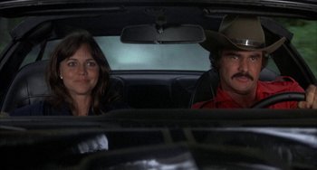 Movie still from “Smokey and the Bandit” (1977), directed by Hal Needham – A man and a woman sitting in the back of a car; Close Up shot, Low angle