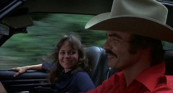 Movie still from “Smokey and the Bandit” (1977), directed by Hal Needham – A man and a woman sitting in the back of a car; Close Up shot, Over the shoulder angle