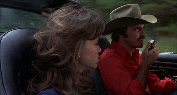 Movie still from “Smokey and the Bandit” (1977), directed by Hal Needham – A man and a woman are sitting in a car; Close Up shot, Over the shoulder angle