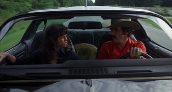 Movie still from “Smokey and the Bandit” (1977), directed by Hal Needham – A man and a woman sitting in the back of a car; Medium shot, Low angle