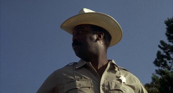 Movie still from “Smokey and the Bandit” (1977), directed by Hal Needham – A man in a cowboy hat is standing in the sun; Close Up shot, Low angle