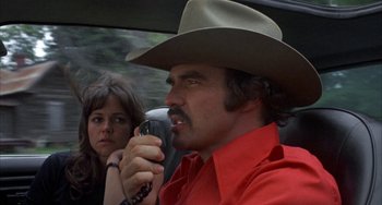Movie still from “Smokey and the Bandit” (1977), directed by Hal Needham – A man in a cowboy hat talking on a walkie talkie; Close Up shot, Low angle