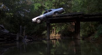 Movie still from “Smokey and the Bandit” (1977), directed by Hal Needham – A police car that is on top of a wooden bridge; Wide shot, Low angle