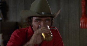Movie still from “Smokey and the Bandit” (1977), directed by Hal Needham – A man in a cowboy hat drinking a beer; Close Up shot, Over the shoulder angle