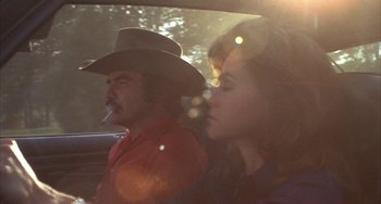 Movie still from “Smokey and the Bandit” (1977), directed by Hal Needham – A man and a woman sitting in the back of a car; Medium shot, Low angle