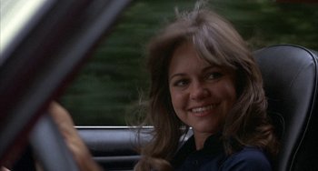 Movie still from “Smokey and the Bandit” (1977), directed by Hal Needham – A woman sitting in the driver's seat of a car; Close Up shot, Over the shoulder angle
