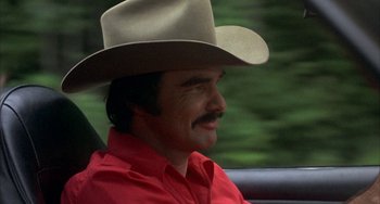 Movie still from “Smokey and the Bandit” (1977), directed by Hal Needham – A man wearing a cowboy hat sitting in the back of a car; Close Up shot, Over the shoulder angle