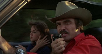 Movie still from “Smokey and the Bandit” (1977), directed by Hal Needham – A man and a woman sitting in the back of a car; Close Up shot, Over the shoulder angle