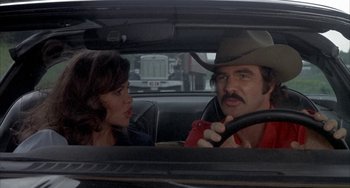 Movie still from “Smokey and the Bandit” (1977), directed by Hal Needham – A man and a woman sitting in the back seat of a car; Close Up shot, Over the shoulder angle