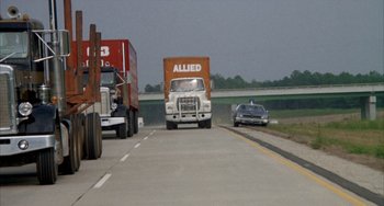 Movie still from “Smokey and the Bandit” (1977), directed by Hal Needham – A truck driving down a highway next to a car; Extreme Wide shot, High angle