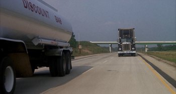 Movie still from “Smokey and the Bandit” (1977), directed by Hal Needham – A truck is driving down the road with a trailer; Extreme Wide shot, High angle