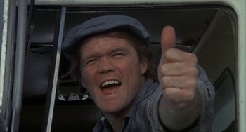 Movie still from “Smokey and the Bandit” (1977), directed by Hal Needham – A man giving a thumbs up while wearing a hat; Close Up shot, Low angle