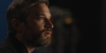 Movie still from “Somebody I Used to Know” (2023), directed by Dave Franco – A person with a beard looking to the side; Close Up shot, Over the shoulder angle