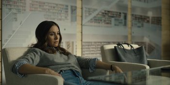 Movie still from “Somebody I Used to Know” (2023), directed by Dave Franco – A woman sitting on a couch in a living room; Medium shot, Low angle