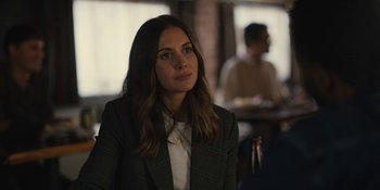 Movie still from “Somebody I Used to Know” (2023), directed by Dave Franco – A woman sitting in front of a table in a restaurant; Close Up shot, Over the shoulder angle