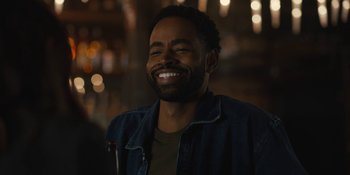 Movie still from “Somebody I Used to Know” (2023), directed by Dave Franco – A man with a beard smiling for the camera; Close Up shot, Over the shoulder angle