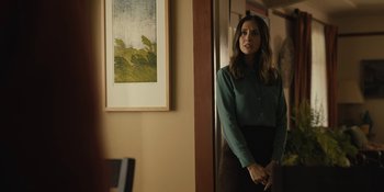 Movie still from “Somebody I Used to Know” (2023), directed by Dave Franco – A woman standing in front of a painting in a room; Medium shot, Over the shoulder angle