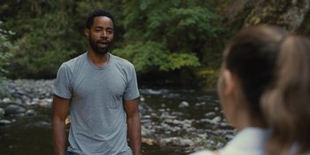 Movie still from “Somebody I Used to Know” (2023), directed by Dave Franco – A man standing in front of a stream talking to a woman; Medium shot, Over the shoulder angle