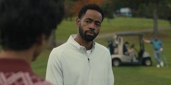 Movie still from “Somebody I Used to Know” (2023), directed by Dave Franco – A man in a white jacket is standing in a field; Close Up shot, Over the shoulder angle