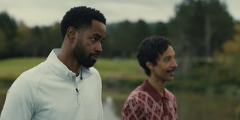 Movie still from “Somebody I Used to Know” (2023), directed by Dave Franco – Two men standing next to each other near a body of water; Medium shot, Over the shoulder angle