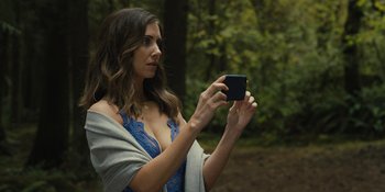 Movie still from “Somebody I Used to Know” (2023), directed by Dave Franco – A woman taking a picture with her cell phone; Close Up shot, Over the shoulder angle