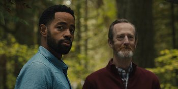 Movie still from “Somebody I Used to Know” (2023), directed by Dave Franco – Two men standing next to each other in the woods; Close Up shot, Over the shoulder angle