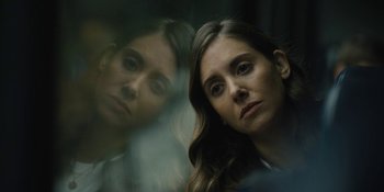 A woman looking at the reflection of herself in a mirror