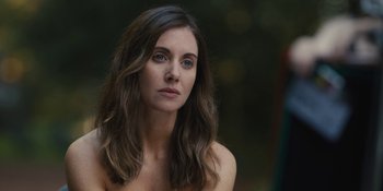 Movie still from “Somebody I Used to Know” (2023), directed by Dave Franco – A beautiful woman with long brown hair and blue eyes looking at the camera; Close Up shot, Over the shoulder angle