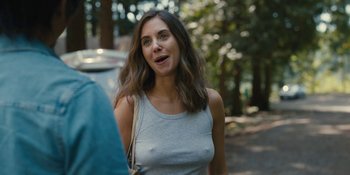 Movie still from “Somebody I Used to Know” (2023), directed by Dave Franco – A beautiful young woman standing next to a tree; Close Up shot, Over the shoulder angle