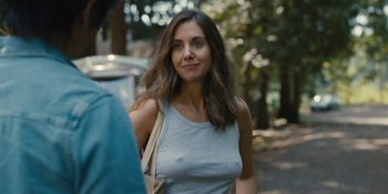 Movie still from “Somebody I Used to Know” (2023), directed by Dave Franco – A beautiful young lady standing next to a tree; Close Up shot, Over the shoulder angle
