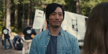 Movie still from “Somebody I Used to Know” (2023), directed by Dave Franco – A person wearing a blue shirt; Close Up shot, Over the shoulder angle