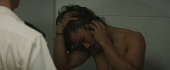 Movie still from “Son of a Gun” (2014), directed by Julius Avery – A young man with wet hair looking in the mirror; Close Up shot, Over the shoulder angle