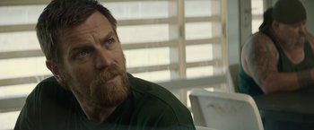 Movie still from “Son of a Gun” (2014), directed by Julius Avery – A person with a beard looking at the camera; Close Up shot, Over the shoulder angle
