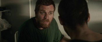 Movie still from “Son of a Gun” (2014), directed by Julius Avery – A man with a goatee stares into a mirror; Close Up shot, Over the shoulder angle