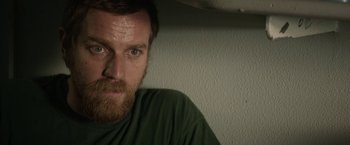 Movie still from “Son of a Gun” (2014), directed by Julius Avery – A person wearing a green shirt; Close Up shot, Over the shoulder angle