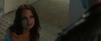 Movie still from “Son of a Gun” (2014), directed by Julius Avery – A beautiful young woman sitting on the ground; Close Up shot, Over the shoulder angle