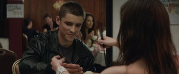 Movie still from “Son of a Gun” (2014), directed by Julius Avery – A young man holding chopsticks while looking at a young woman; Close Up shot, Over the shoulder angle