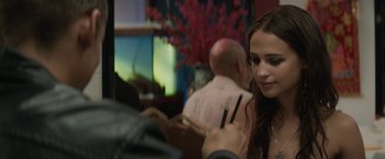 Movie still from “Son of a Gun” (2014), directed by Julius Avery – A woman holding chopsticks while looking at a man; Close Up shot, Over the shoulder angle