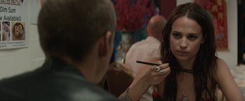 Movie still from “Son of a Gun” (2014), directed by Julius Avery – A woman is getting her makeup done by a man; Close Up shot, Over the shoulder angle