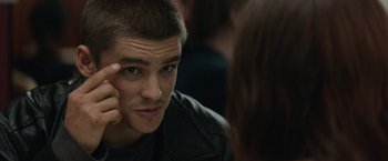 Movie still from “Son of a Gun” (2014), directed by Julius Avery – A young man looking into a mirror while holding his hand up to his eye; Close Up shot, Over the shoulder angle