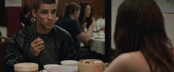 Movie still from “Son of a Gun” (2014), directed by Julius Avery – A group of people sitting at a table with food; Close Up shot, Over the shoulder angle